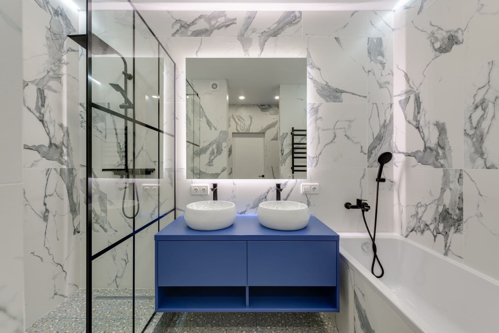 Marble-tiled bathroom with twin basins